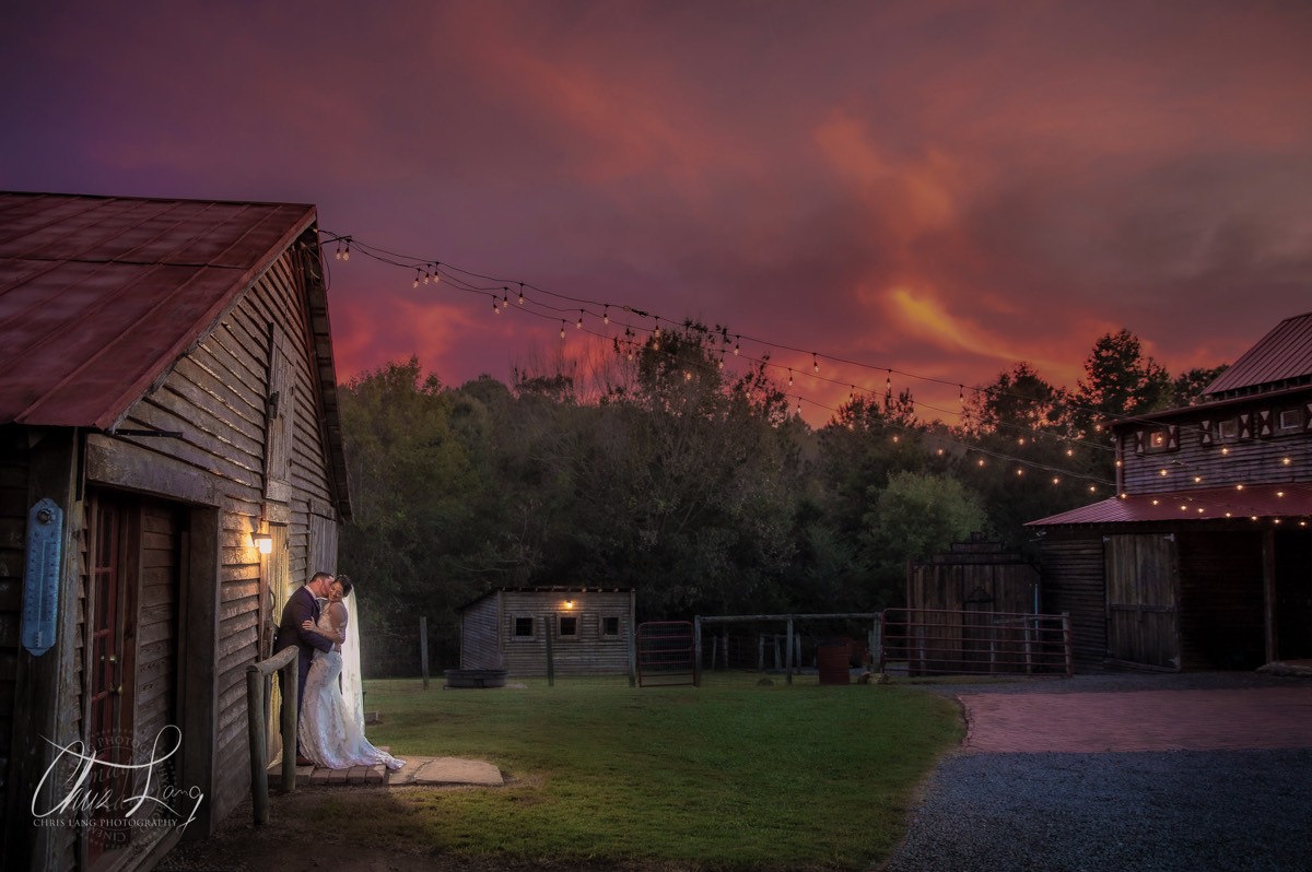 bride and groom by a barn - farm house weddings - sunset photo - wilmington nc wedding photographers - creative wedding photo - signature portrats - wedding ideas - bride - groom - wedding dress - chris lang photography